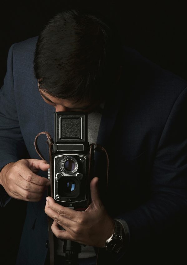 Professional photographer with vintage medium format camera, Portrait of a man in suit with twin lens classic camera in photography studio, Vintage camera collecting is trendy lifestyle.